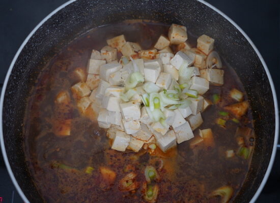Déplacez doucement le bloc de tofu dans le bouillon pour séparer les dés sans les casser.
