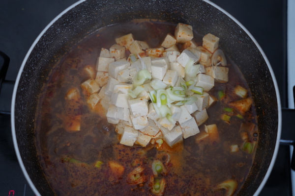 Déplacez doucement le bloc de tofu dans le bouillon pour séparer les dés sans les casser.